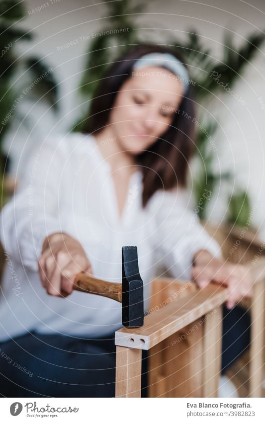 Nahaufnahme von jungen Frau Montage von Möbeln zu Hause arbeiten mit Hammer. DIY-Konzept es selbst machen diy Zusammenbau heimwärts Kaukasier im Innenbereich