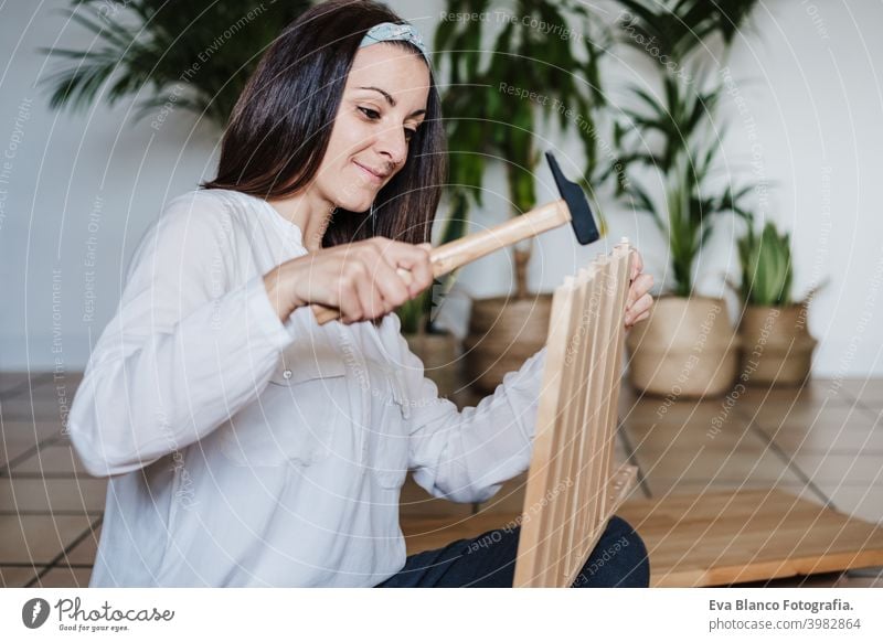 Nahaufnahme von jungen Frau Montage von Möbeln zu Hause arbeiten mit Hammer. DIY-Konzept es selbst machen diy Zusammenbau heimwärts Kaukasier im Innenbereich