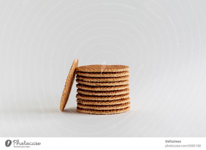 Ein Stapel holländischer Stroopwafels (Sirup- oder Karamellwaffeln) mit einem Keks an der Seite auf weißem Hintergrund mit Kopierraum, Nahaufnahme backen