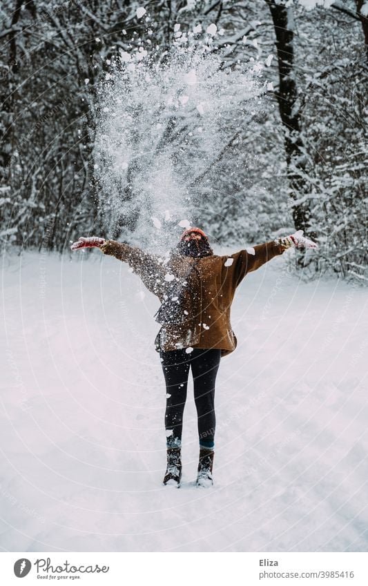 Frau wirft mit Schnee in verschneiter Landschaft im Winter. werfen weiß Wald winterlich Spaß Wintertag Mensch Schneelandschaft kalt Winterlandschaft