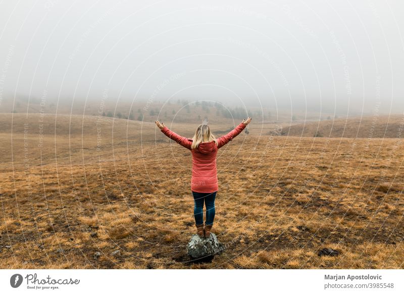 Junge Frau erkundet die Natur an einem nebligen Wintermorgen Abenteuer Herbst Cloud kalt Landschaft Fundstück Erkundung erkunden Entdecker Feld Nebel Freiheit