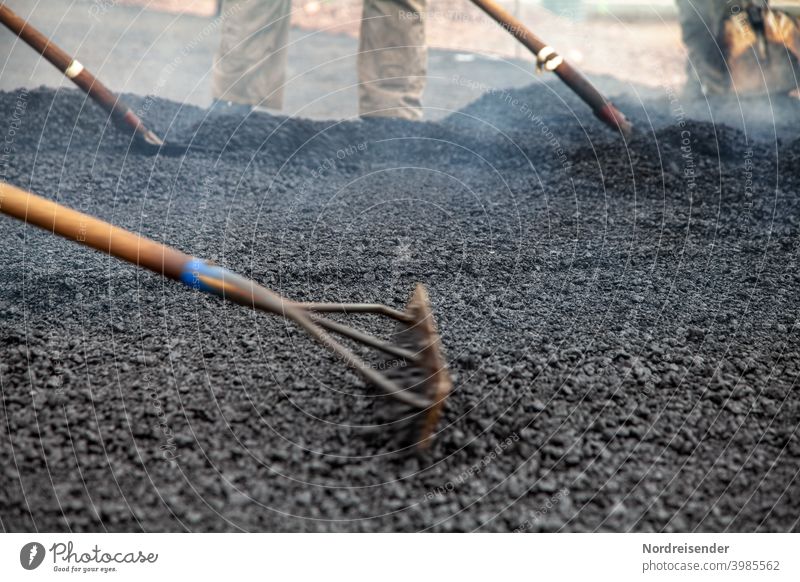 Schwerstarbeit bei der Asphaltierung einer neuen Straße bauarbeiter straße straßenbau schwer schwerindustrie bauarbeiten heiß warm teer asphalt baumaschine