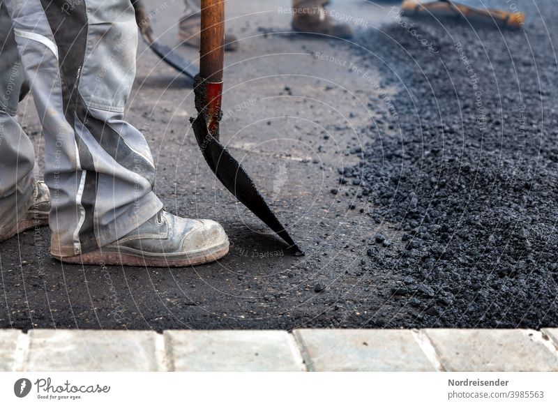 Schwerstarbeit bei der Asphaltierung einer neuen Straße bauarbeiter straße straßenbau schwer schwerindustrie bauarbeiten heiß warm teer asphalt baumaschine