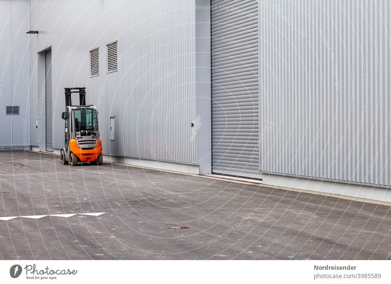 Gabelstapler vor einer modernen Industriefassade gabelstapler fabrik logistik transport lager industrie beförderung laden last heben tor rolltor neu fertigung