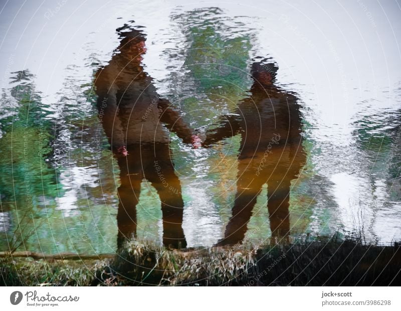 Zeitgeschichte, Bund fürs Leben im fließenden Wandel Reflexion & Spiegelung Teich Ehepaar Wasseroberfläche Natur ruhig Ufer Gras Silhouette Teichufer wellig