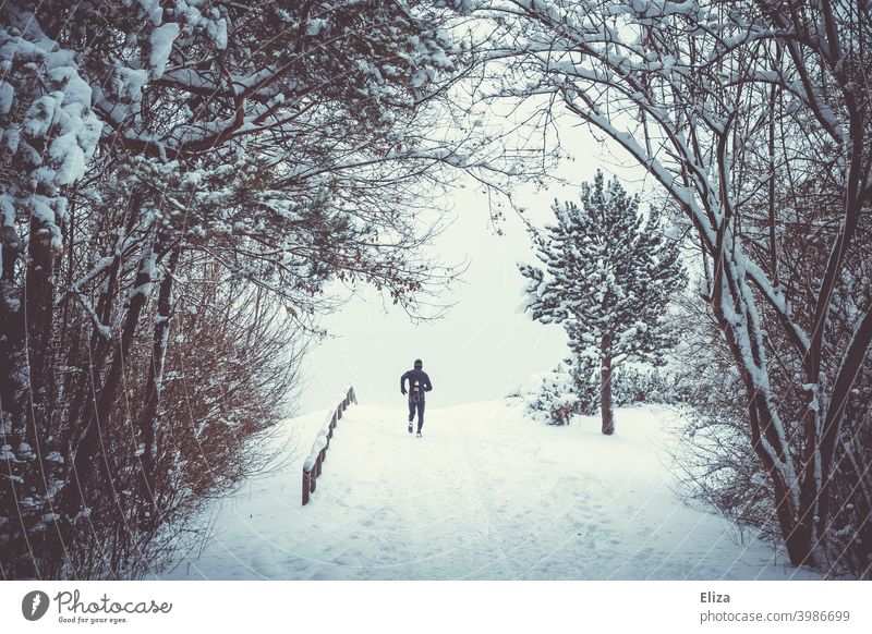 Person joggt in Schneelandschaft Joggen Winter Sport Fitness Park Jogger Training Läufer Winterlandschaft Bewegung dunkel bewölkt draußen Natur