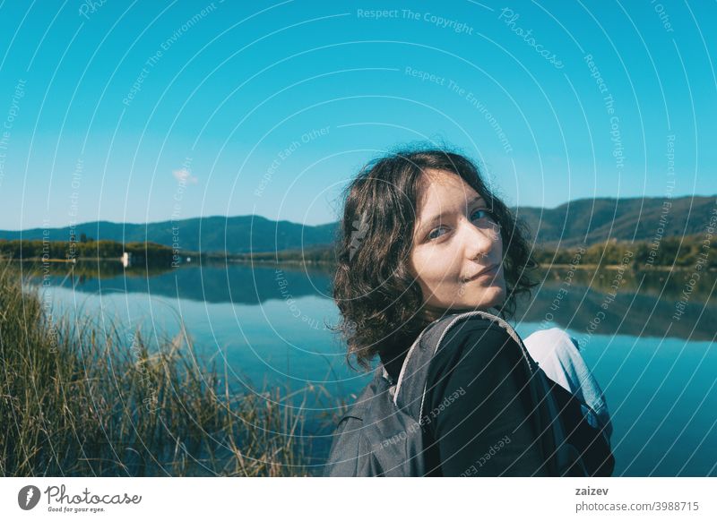 Mädchen sitzt auf dem Rand des Banyoles See mit der Landschaft im Wasser reflektiert Harmonie Meditation entspannend horizontal Profil Ruhe Person nachdenken