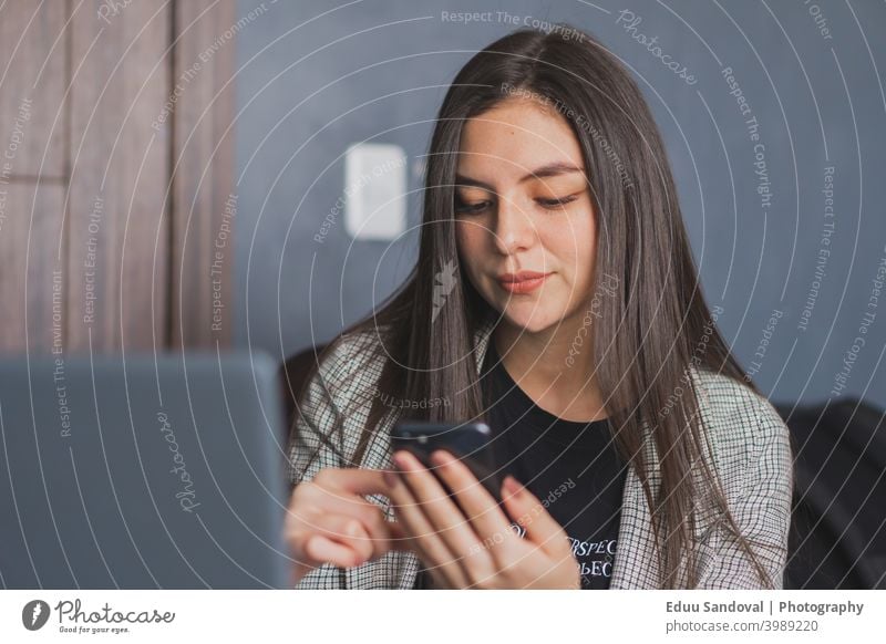 Junge Frau prüft und tippt auf ihrem Mobiltelefon. schwarz Heißgetränk Smartphone Lifestyle Glück schön Beteiligung Person Blick Texten Tasse Mädchen Cafés