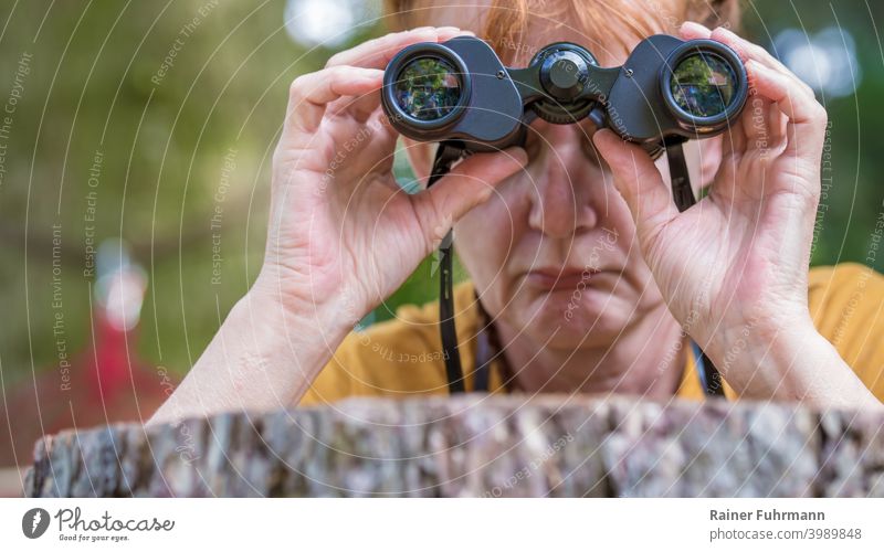 Nahaufnahme von einer Frau, die enttäuscht durch ein Fernglas blickt Farbfoto Außenaufnahme beobachten Blick Tag Mensch Erwachsene entdecken Neugier