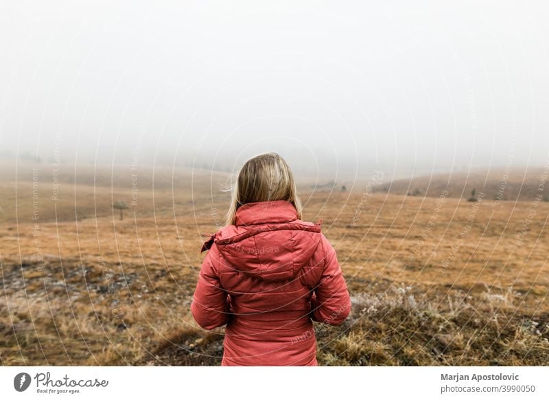 Junge Frau erkundet die Natur an einem nebligen Wintermorgen Abenteuer Herbst Cloud kalt Landschaft Fundstück Erkundung erkunden Entdecker Feld Nebel Freiheit