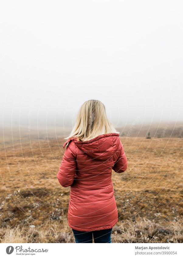 Junge Frau erkundet die Natur an einem nebligen Wintermorgen Abenteuer Herbst Cloud kalt Landschaft Fundstück Erkundung erkunden Entdecker Feld Nebel Freiheit