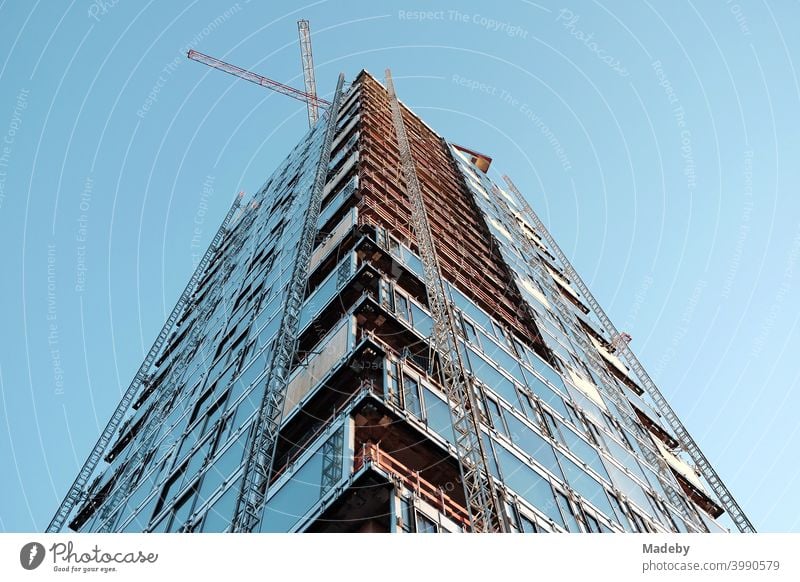 Rohbau eines modernen Hochhaus mit Luxusapartment mit zwei Baukränen vor hellblauem Himmel im Westend von Frankfurt am Main in Hessen Immobilie Wolkenkratzer