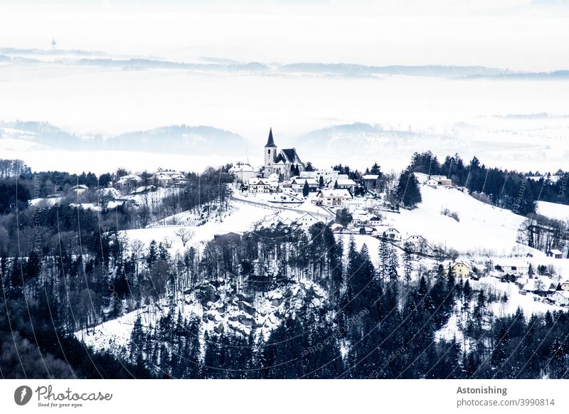 kleiner, eingeschneiter Ort in einer Hügellandschaft Allerheiligen im Mühlkreis Landschaft Natur Dorf Kirche Kirchturm Österreich Mühlviertel Winter Schnee