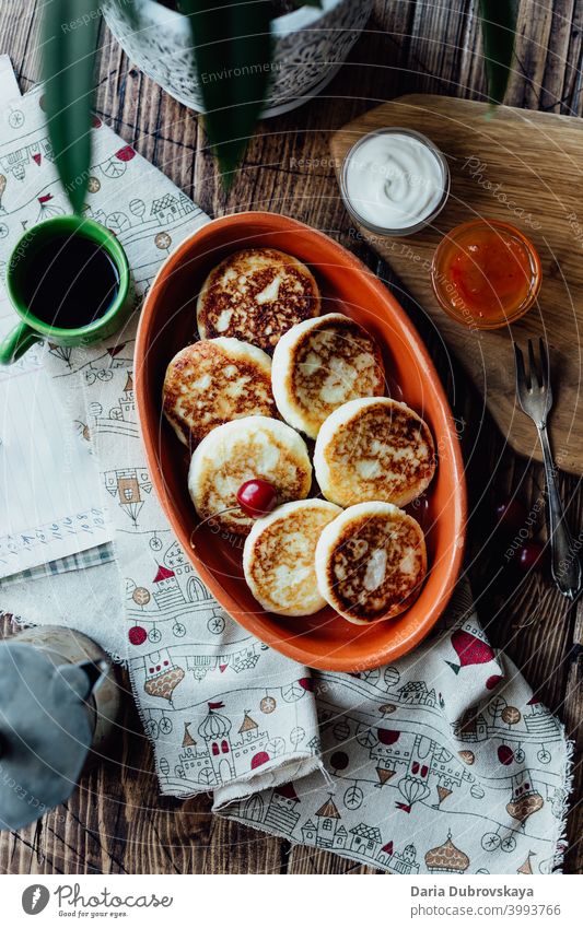 Hüttenkäse-Pfannkuchen auf einem Holztisch süß Frühstück hölzern Speise Dessert traditionell Tisch Cottage Käse Teller Quark Molkerei gebraten Mahlzeit Morgen