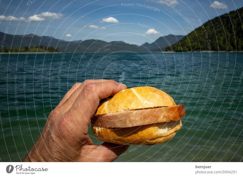 Leberkäsesemmel am Walchensee Semmel See Bayern Sommer Hand halten Brotzeit Brötchen sonnig wolke ufer berg alpen voralpen männlich snack bayerisch Fleisch