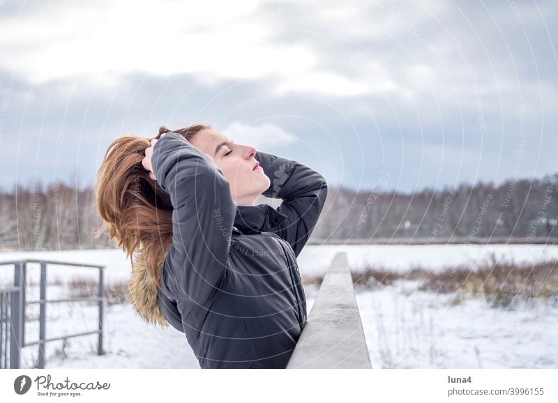 entspanntes  Mädchen  genießt Sonne im Winter Schnee Wald Winterwald Frost genießen sonnen kalt Harre Frisur Kälte Jugendliche Erholung warme Kleidung lachen