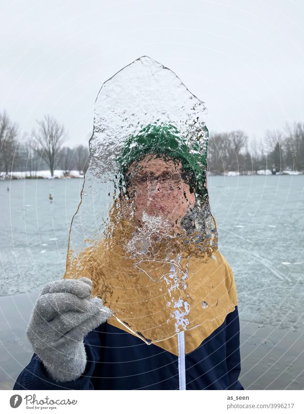 Durchblick Junge Eis durchsichtig kalt Winter Frost gefroren Schnee frieren Eiskristall Kristallstrukturen Natur Wasser Mütze See Handschuh Kindheit