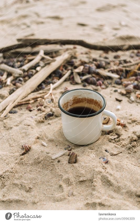 Emaille-Becher mit Heißgetränk stehend im Sand an einem wilden Strand Tasse Picknick Herbst Tee kalt Stillleben Getränk trinken heiß Metall Flucht