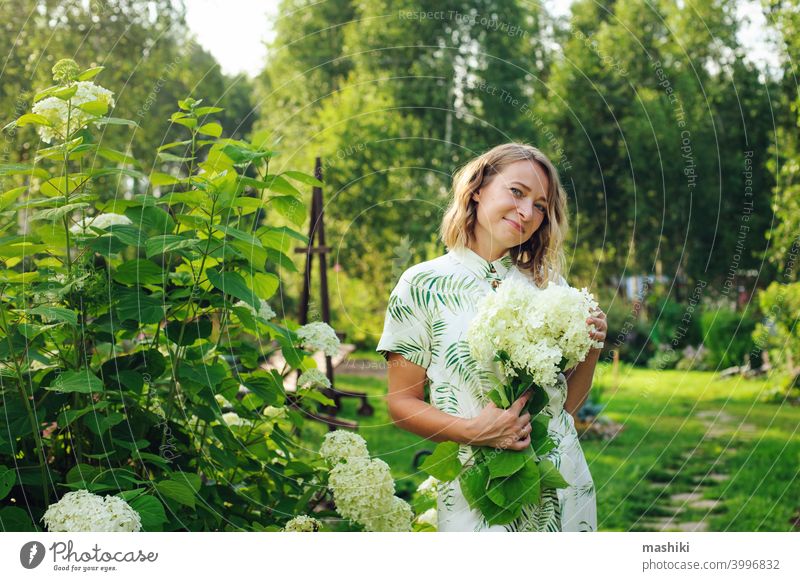 schöne junge Frau Gärtnerin posiert mit Hortensien Blumen im Sommer Hütte Garten Person Gartenarbeit im Freien Pflanze Lifestyle Natur Erwachsener Mädchen