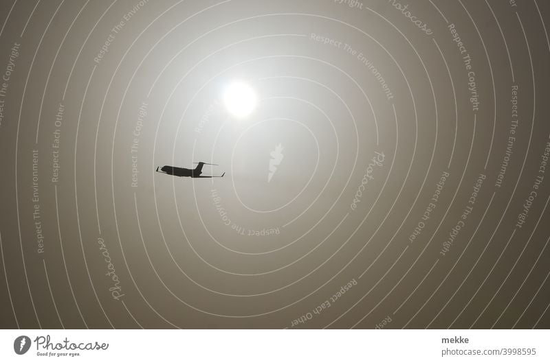 Ein Flugzeug startet in den diffus leuchtenden Himmel Start Flugzeugstart Abheben Sonne Sonnenlicht milchig Licht Staub staubschicht Saharastaub Luftverkehr