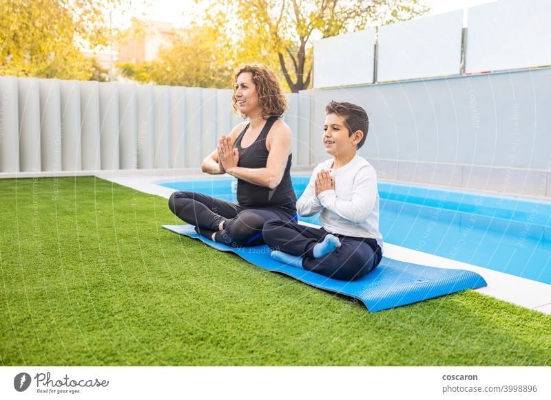 Mutter und Sohn machen Yoga-Übungen in ihrem Hausgarten Aktivität Asien Körper Windstille Kind Kindheit niedlich Familie Familien-Yoga Frau passen Garten