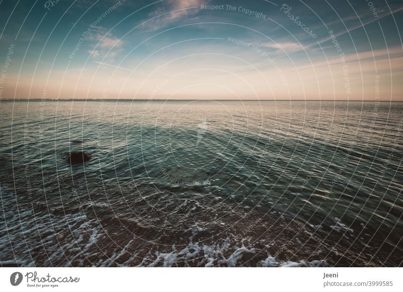 Weiter Blick vom Ufer der Ostsee | Der Himmel ist zartblau, leichte Wolken sind am Himmel, die Strömung des Meeres ist zu erkennen Horizont Ferne Ruhe Wasser