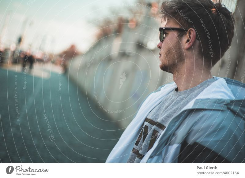 junger Mann Schaut in die Ferne Rostock Brille Hipster deep Tiefenunschärfe blau Meer tief Bart Dreitagebart