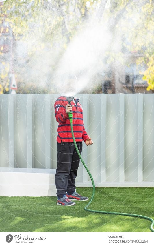 Kleiner Junge bewässert das Gras im Garten Aktion Aktivität Kind Kindheit Kinder Tropfen genießen Familie Springbrunnen frisch Spaß Gartenarbeit grün