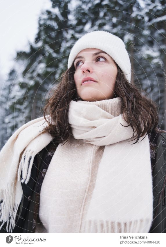 Junges Mädchen, Frau geht in schönen Winterwald unter Bäumen, Tannen, mit Schnee bedeckt. Magnificent Natur und Ansichten. Modisches Bild, Kleidung, Parka, Hut, Handschuhe, Blue Jeans