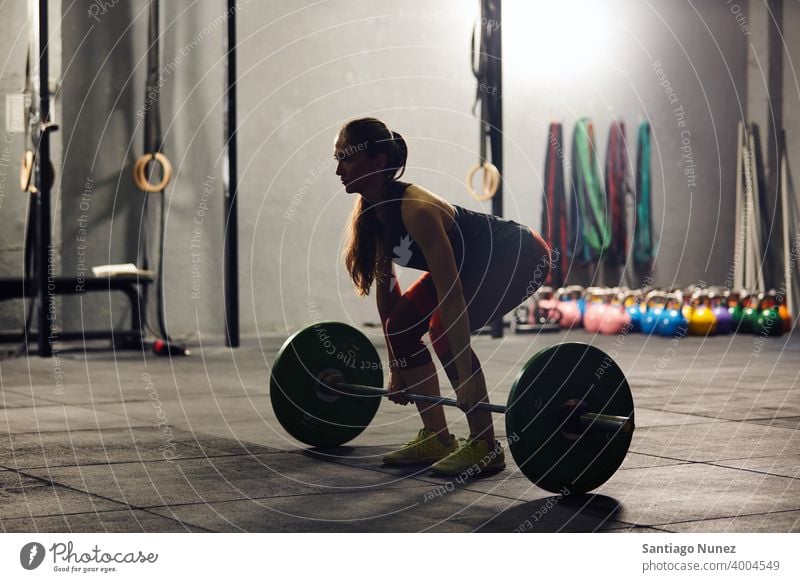 Kaukasische Frau hebt eine Langhantel. Crossfit Funktionstraining Fitnessstudio Gesundheit Sport Training Übung Lifestyle passen Erwachsener Vitalität