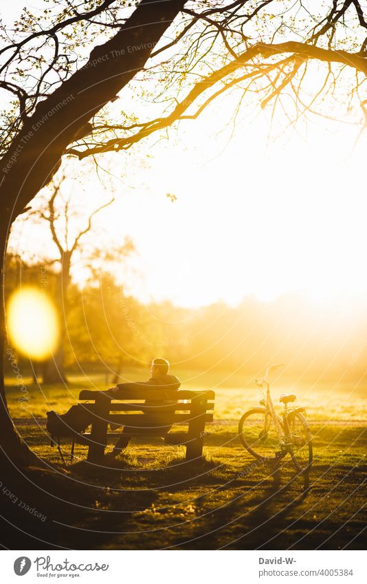 Radtour - Mann ruht sich im Sonnenlicht etwas aus und macht eine Pause Auszeit Sonnenuntergang Fahrrad Bank sitzen Natur draußen abschalten Schönes Wetter