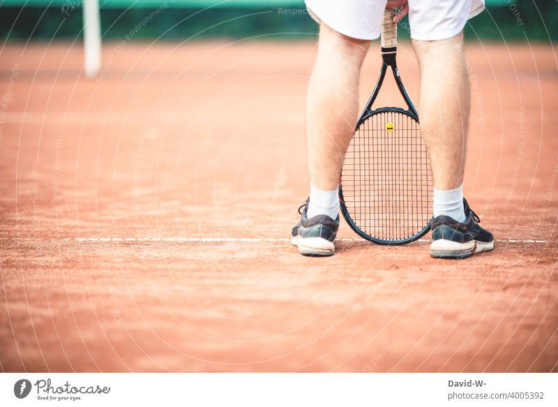 Mann steht lässig mit einem Tennisschläger auf dem Tennisplatz Sport Sportler cool sportlich Freizeit & Hobby