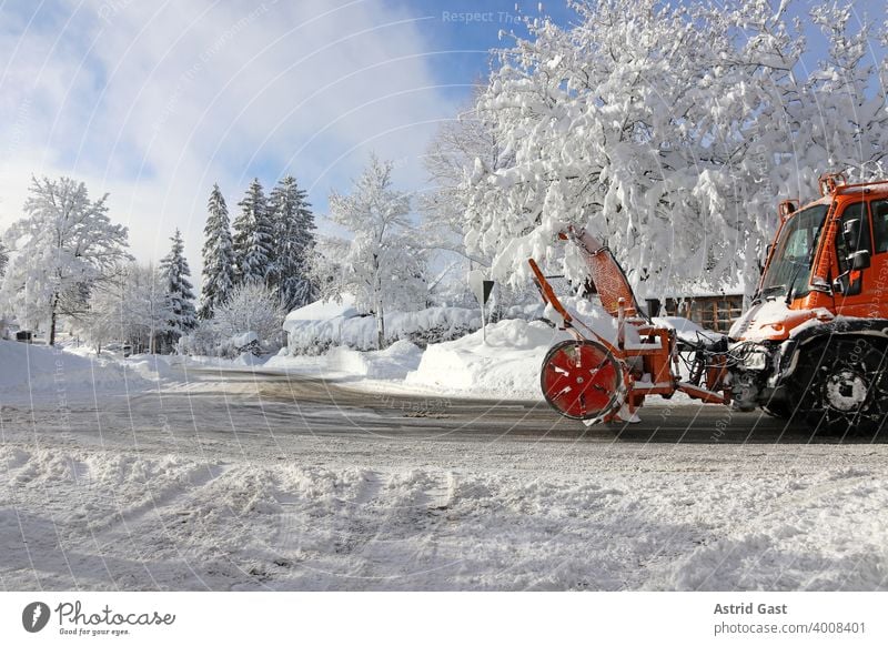 Ein Schneepflug mit einer Schneefräse fährt im Winter in einer Stadt durch die Straße um den hohen Schnee wegzuräumen winter schnee straße stadt schneeflug