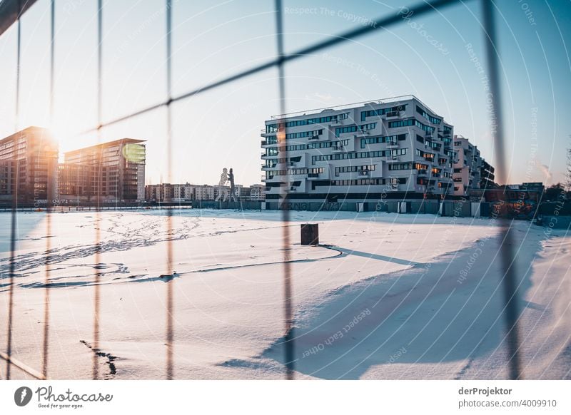 Molecule Man im Winter mit Neubau Mauer Wand trendy Licht Tag Textfreiraum Mitte Außenaufnahme Experiment Textfreiraum oben Berlin Farbfoto Himmel (Jenseits)