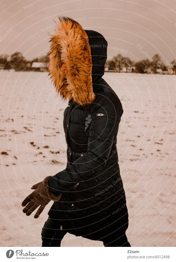 Frau spaziert bei Schneefall durch die Straßen spaziergang Spaziergang Winterspaziergang Kaminsims kunstpelz lachen lächeln Wärme schneefall Schafe Kälte weiss