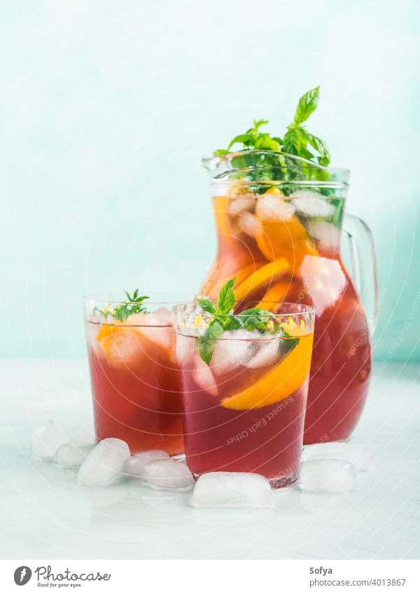 Frischer roter Coktail-Sangria in Krug und Gläsern Cocktail Mocktail trinken Wein Zitrusfrüchte orange Limonade Zitrone Frucht Sommer Dekor Blatt Glas Saft