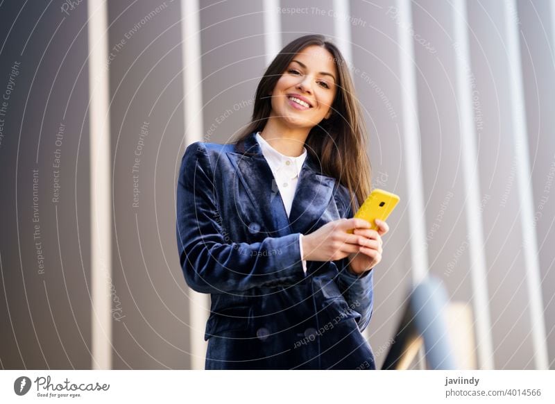 Business-Frau im blauen Anzug mit Smartphone in einem Bürogebäude. Geschäftsfrau Mädchen klug Telefon Person Gerät Lifestyle urban Hintergrund Dame elegant