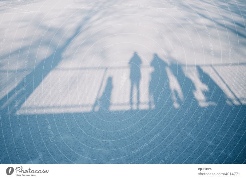 Schatten mehrerer Menschen die auf einer Brücke stehen und auf einen zugefrorenen See schauen Steilshoop blau schatten Außenaufnahme Farbfoto Stadt Tag trist