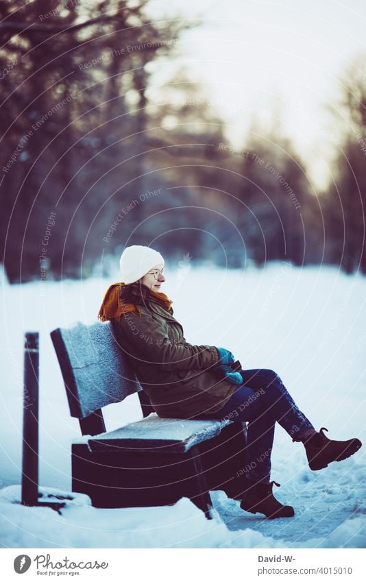 wintereinbruch und Schnee - Frau sitz bei kälte auf einer Bank Winter Wintereinbruch sitzen Wetter schön genießen Wintertag Winterstimmung kalt winterlich Frost