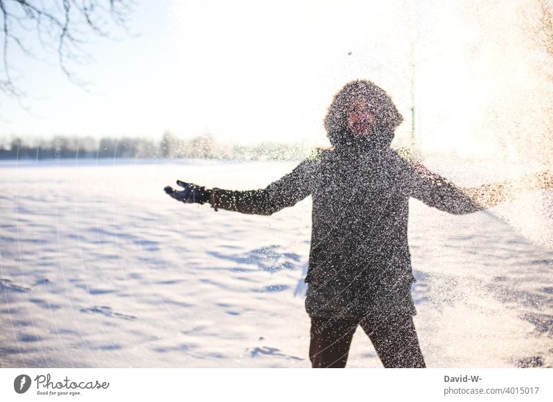 Mann im Winter im Schnee schneien Wintereinbruch Schneefall weiß Winterstimmung Sonnenlicht sonnentrahlen Schneeflocken Freude spass Wintertag Schneegestöber