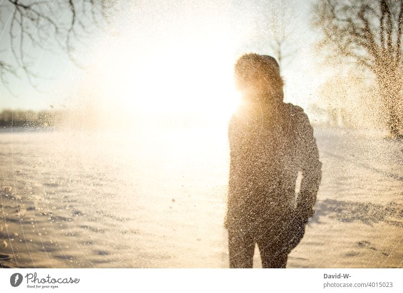 Mann im Schnee im Licht der Sonne Winter Sonnenstrahlen Wintermorgen Winterstimmung kalt Schönheit Natur Wintereinbruch Schneefall Wintertag Landschaft weiß