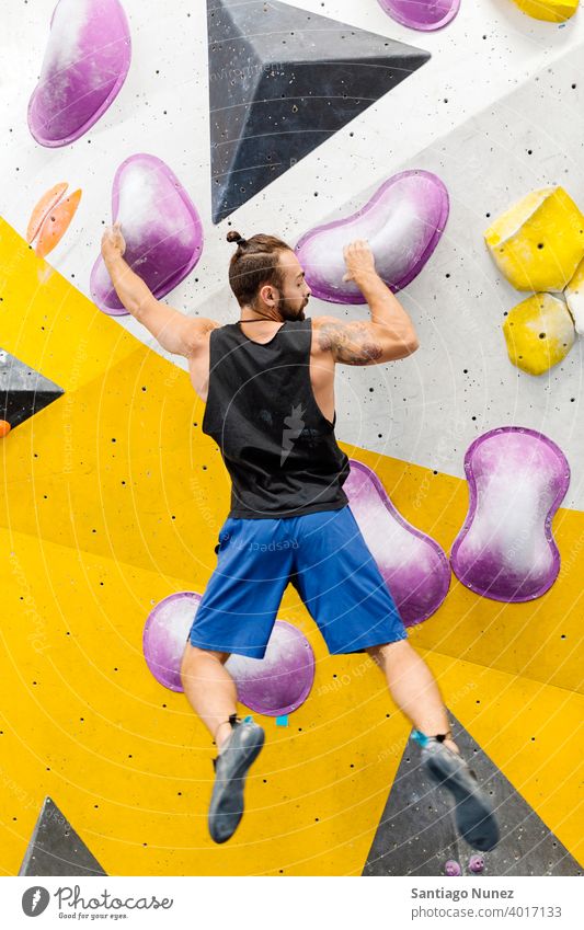 Felskletterer Frau schaut auf Smartphone. Mann Aufsteiger Klettern Felsen im Innenbereich Wand Rückansicht Fitnessstudio Training jung Sport Freizeit aktiv