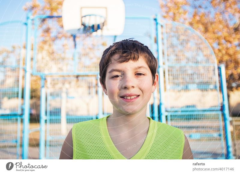 Porträt eines jungen männlichen Teenagers mit ärmellosen stehend auf einer Straße Korbplatz beim Lächeln in die Kamera Basketball Gericht Spieler wirklich