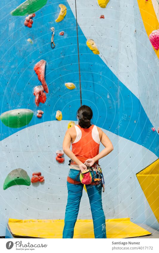 Frau macht sich bereit für das Klettern in der Halle. Aufsteiger Hände unkenntlich Rückansicht Magnesium Tasche Felsen weiß im Innenbereich Wand Fitnessstudio