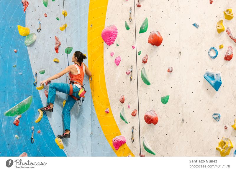 Frau beim Klettern in der Halle. Aufsteiger Felsen Rückansicht Training unkenntlich im Innenbereich Wand Fitnessstudio jung Sport Freizeit aktiv Sicherheit