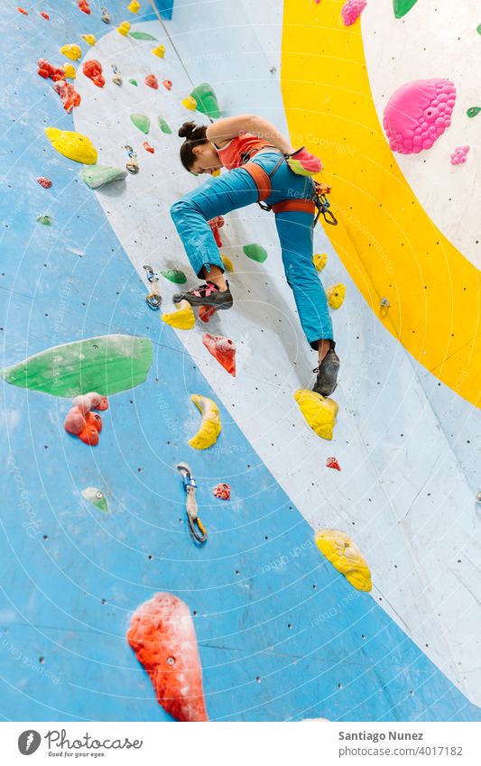 Frau beim Klettern in der Halle. Aufsteiger Felsen Rückansicht Training unkenntlich im Innenbereich Wand Fitnessstudio jung Sport Freizeit aktiv Sicherheit