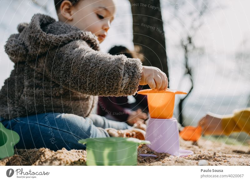 Kind spielt im Freien mit Sand Kindheit 1-3 Jahre authentisch Frühling Farbfoto Kleinkind Mensch Lifestyle Spielen Fröhlichkeit Leben Kindheitserinnerung Glück