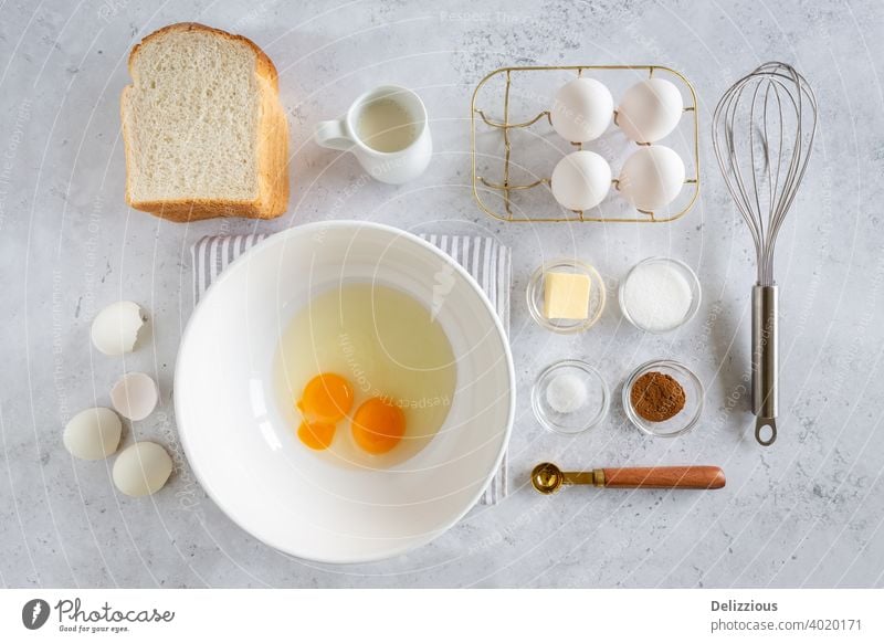 Flat Lay von Zutaten für die Zubereitung von leckeren French Toast (oder wentelteefjes in Niederländisch) auf weißem grauen Hintergrund, Lebensmittel knolling