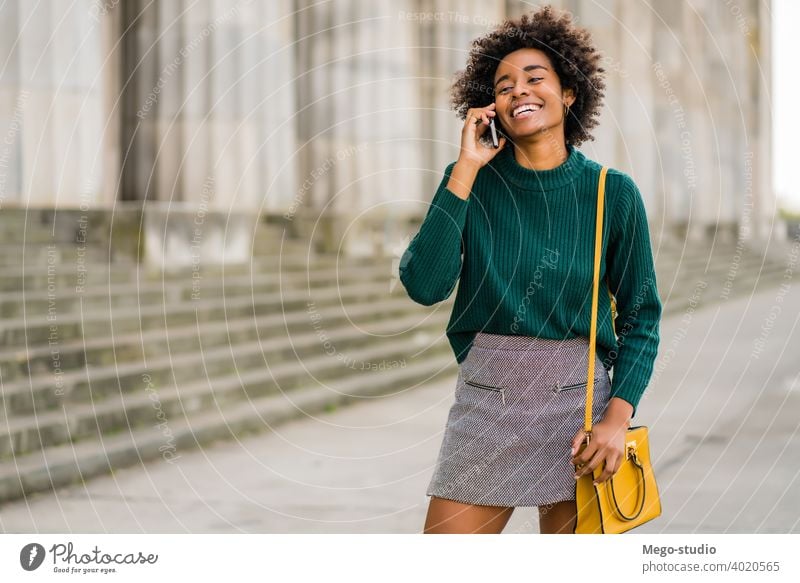 Geschäftsfrau beim Telefonieren im Freien. Afro-Look Business Frau Mobile reden modern Stil brünett Apparatur positiv Konzept Anschluss Anwendung SMS Texten