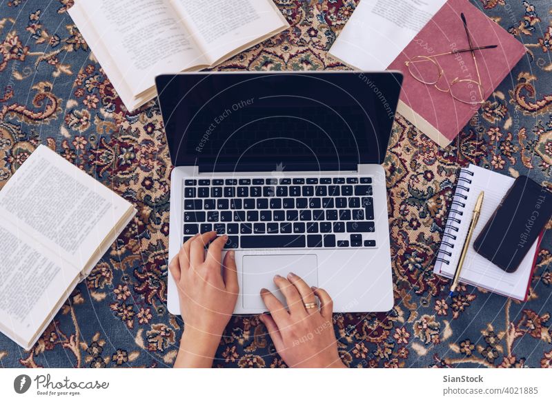 Junge Frau liegt auf dem Teppich und studiert zu Hause. arbeiten Lügen schreibend Buch Schreibstift Bücher lesen Hände Hausaufgabe Brille jung Mädchen Kaukasier